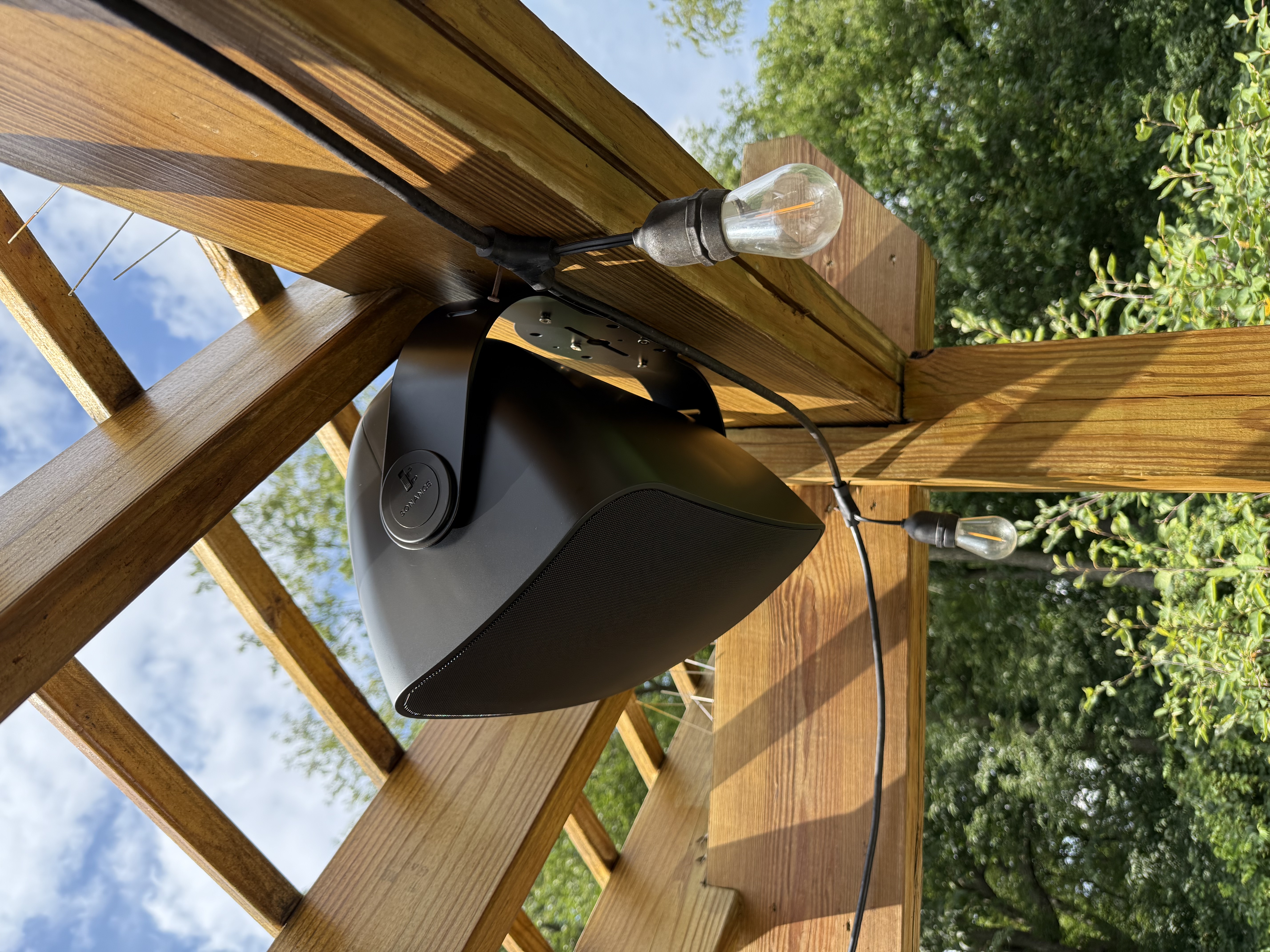 Outdoor pergola installation with mounted landscape speaker and bistro lighting in a Naperville backyard