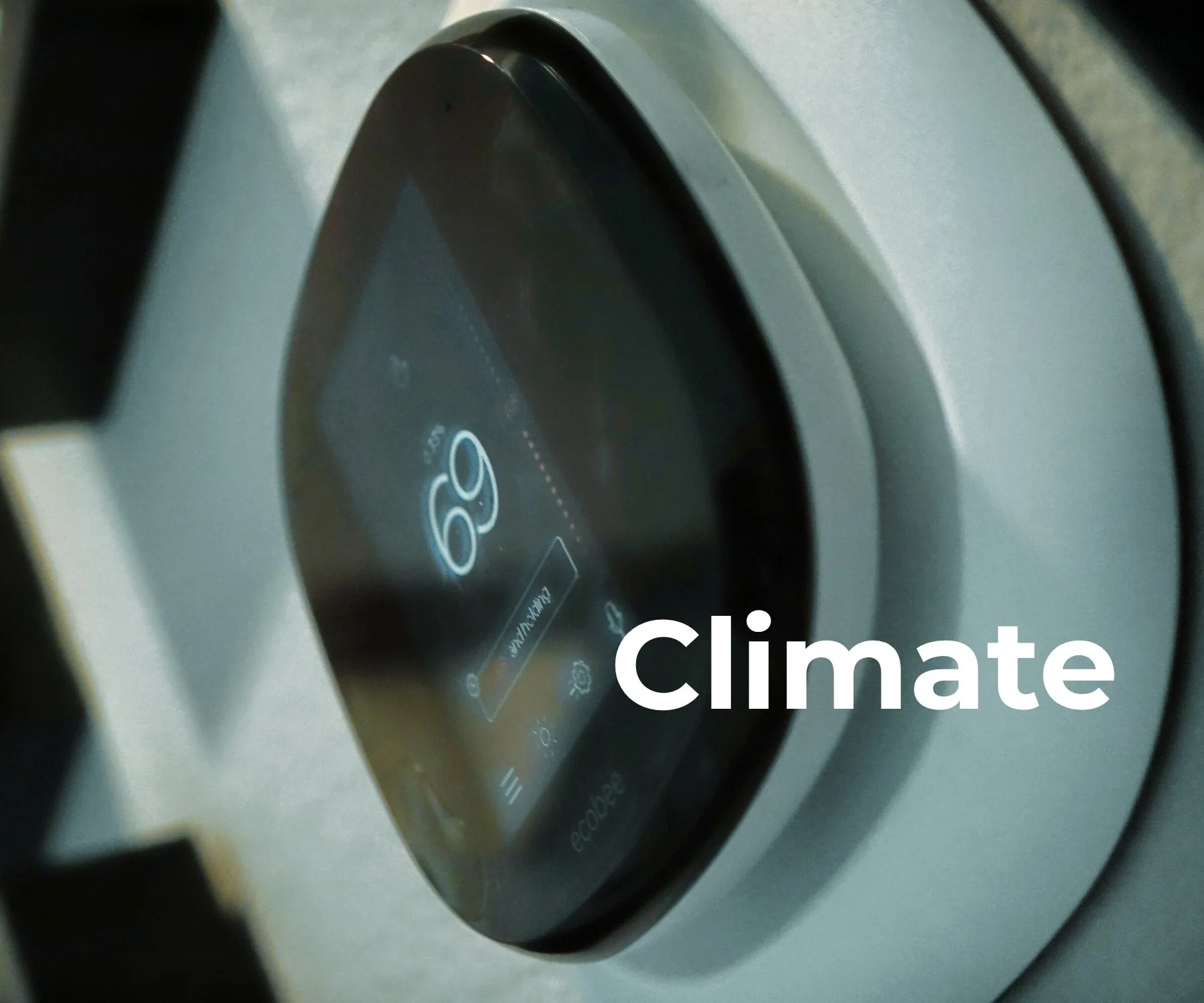 Close-up of an Ecobee smart thermostat displaying sixty-nine degrees on a wall-mounted touchscreen